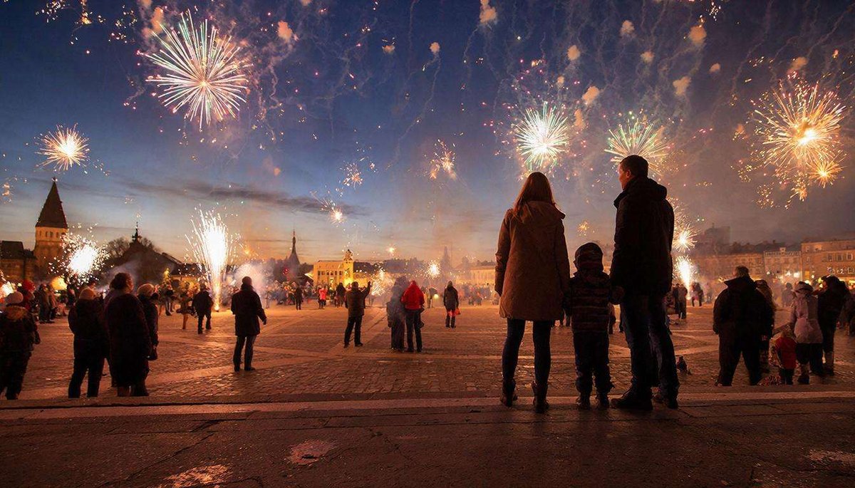 A family watches New Year's fireworks in the square.